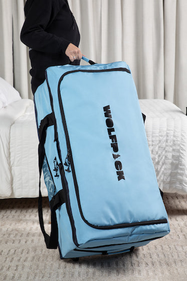 Blue WOLFPACK travel upright with woman holding in hotel room
